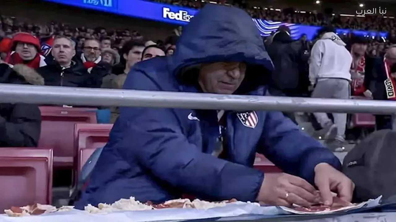 مشجع يحضر الطعام في المدرجات خلال مباراة أتلتيكو وتوتنهام